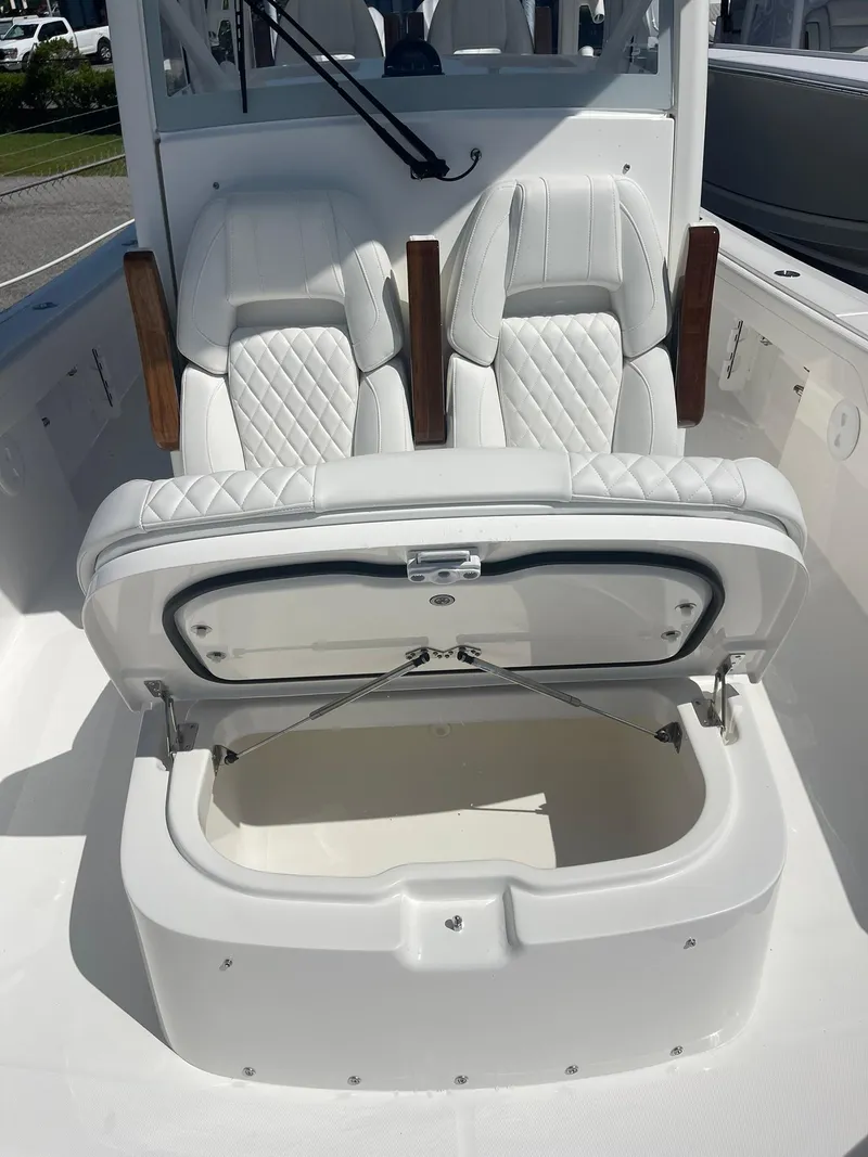 Slide: The Image of 2026 Regulator 30XO boat with open storage compartment and cushioned seating. - 14