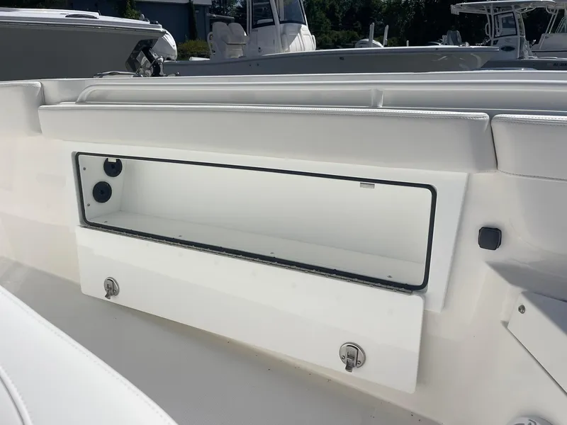 Slide: The Image of 2026 Regulator 30XO boat storage compartment with open hatch, showcasing sleek white interior design. - 15