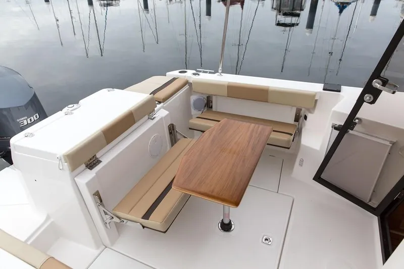 Slide: The Image of Manufacturer Provided Image: 2024 Ranger Tugs R-27 boat interior with seating and wooden table. - 12