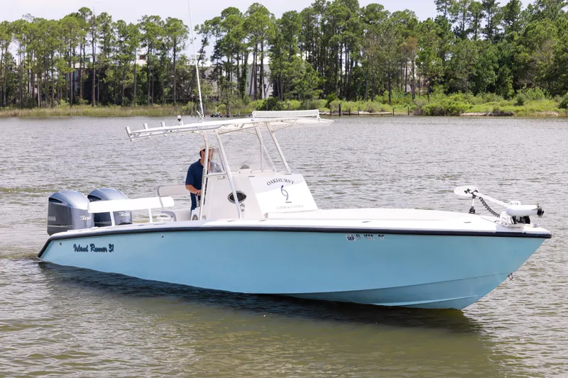 Slide: The Image of 1999 Island Runner 31 boat on water, featuring dual Yamaha engines, surrounded by trees. - 1