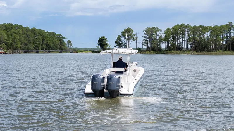 Slide: The Image of A 1999 Island Runner 31 boat cruising on a scenic lake with trees in the background. - 11