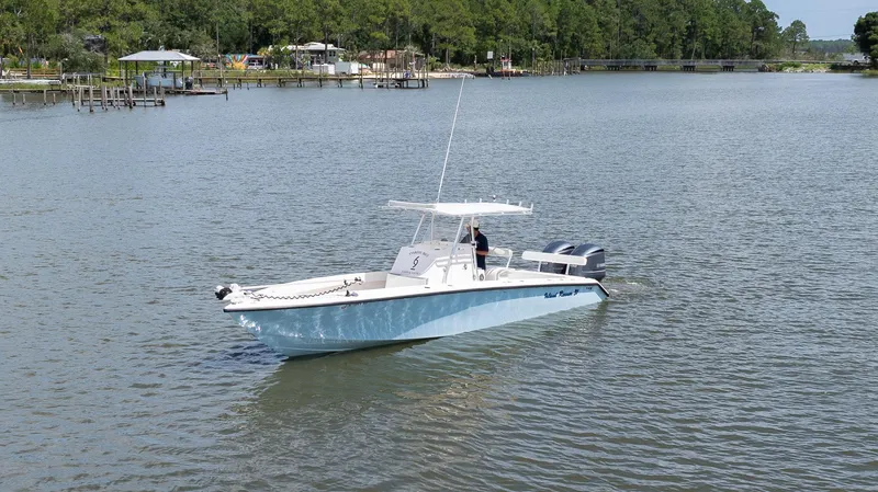 Slide: The Image of 1999 Island Runner 31 boat cruising on a calm river with lush green surroundings. - 14