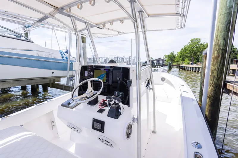 Slide: The Image of 1999 Island Runner 31 boat interior with steering console, docked near other boats. - 16
