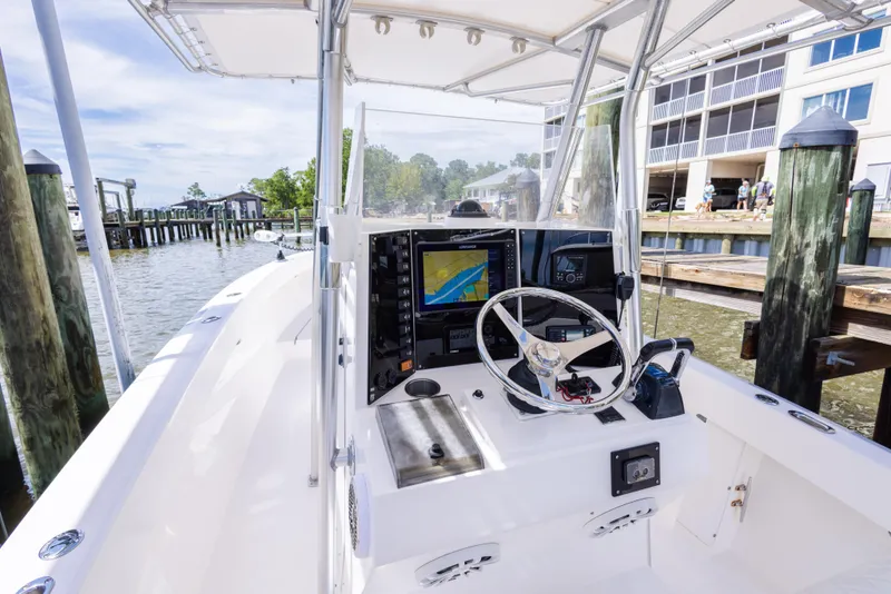 Slide: The Image of 1999 Island Runner 31 boat cockpit with steering wheel and navigation system at a marina. - 17