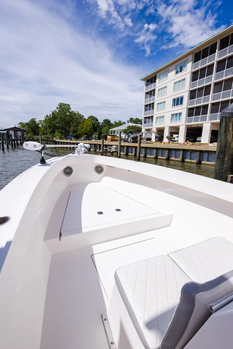 Slide: The Image of 1999 Island Runner 31 boat docked near waterfront building under blue sky. - 25