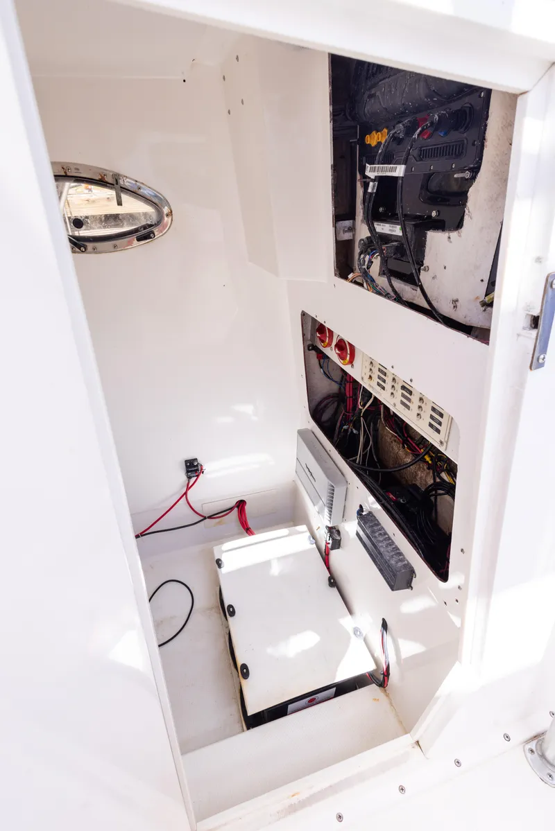 Slide: The Image of Electrical compartment of a 1999 Island Runner 31 boat, featuring wiring and equipment. - 28