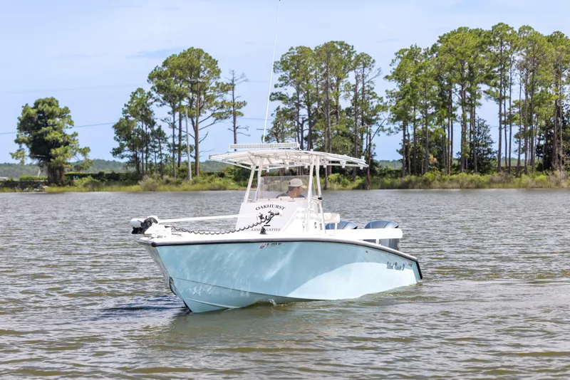 Slide: The Image of 1999 Island Runner 31 boat cruising on a calm lake with trees in the background. - 3