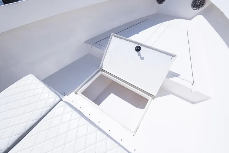 Slide: The Image of Open storage compartment on 1999 Island Runner 31 boat with white cushioned seating. - 30