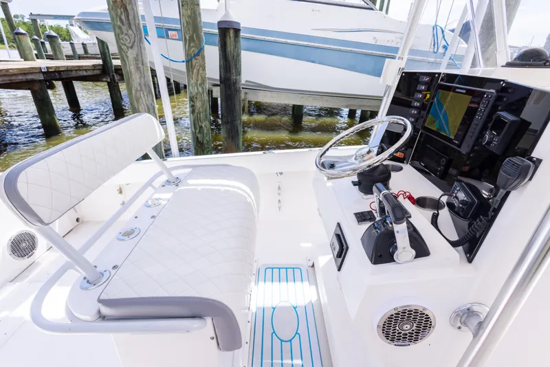 Slide: The Image of 1999 Island Runner 31 boat cockpit with steering wheel, navigation equipment, and cushioned seating. - 35