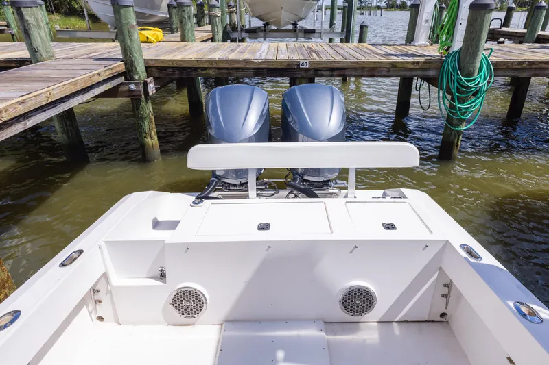 Slide: The Image of 1999 Island Runner 31 boat docked, featuring dual outboard motors and a clean deck. - 36