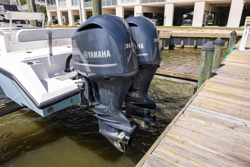 Slide: The Image of Twin Yamaha 300 outboard motors on a 1999 Island Runner 31 boat at a dock. - 38