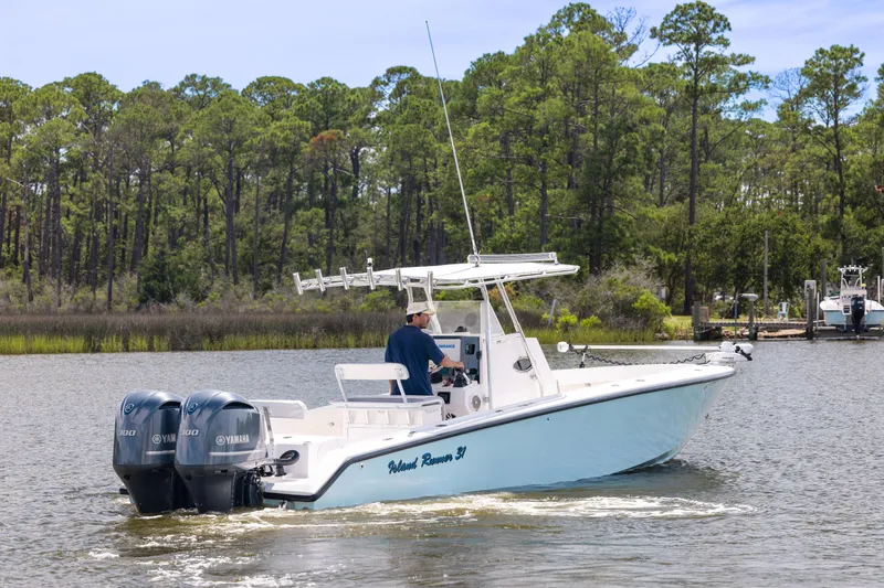 Slide: The Image of 1999 Island Runner 31 boat with dual Yamaha engines on a scenic waterway. - 6