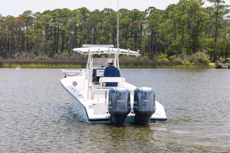 Slide: The Image of 1999 Island Runner 31 boat with dual Yamaha 300 engines on a calm lake. - 8