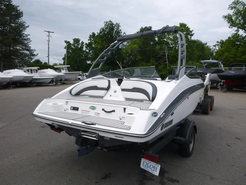 Slide: The Image of 2020 Yamaha Boats 195S on trailer, parked outdoors with other boats in background. - 3