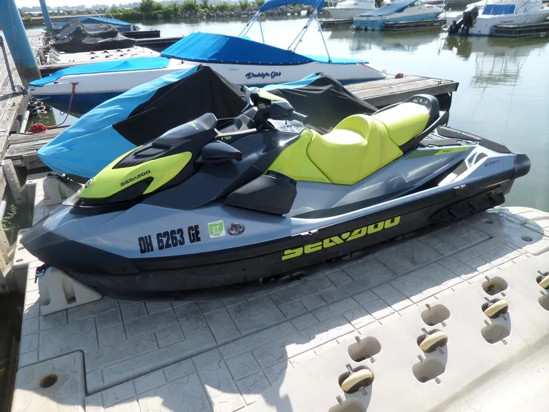 Slide: The Image of 2021 Sea-Doo GTI SE 170 jet ski docked at marina, featuring vibrant yellow and gray design. - 0