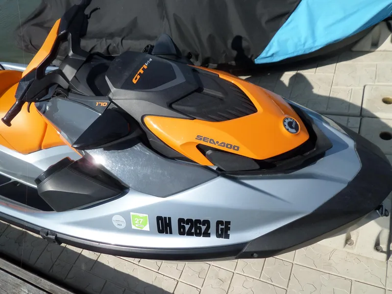 Slide: The Image of 2021 Sea-Doo GTI SE 170 jet ski in orange and gray on dock. - 18