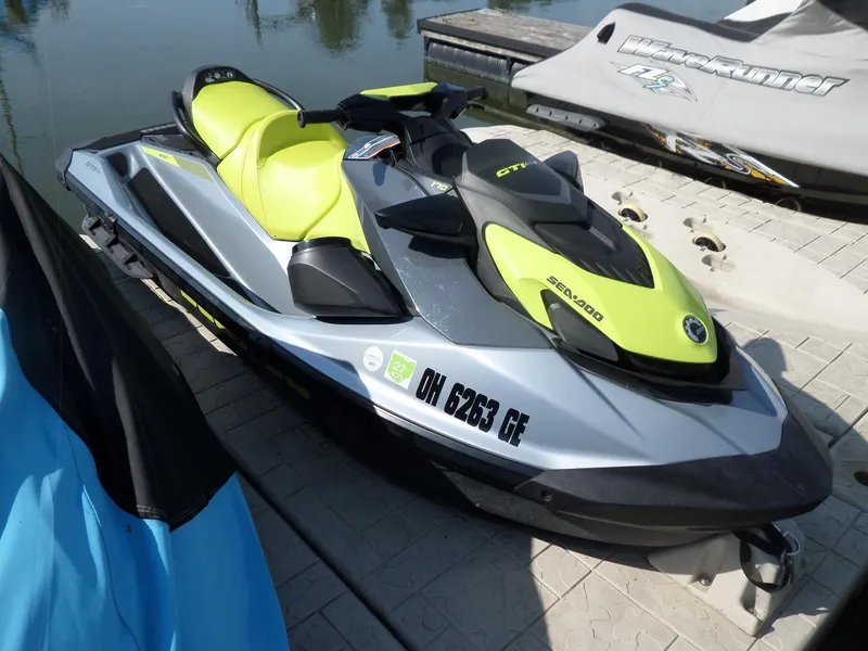 Slide: The Image of 2021 Sea-Doo GTI SE 170 jet ski with vibrant yellow and black design docked by the water. - 4