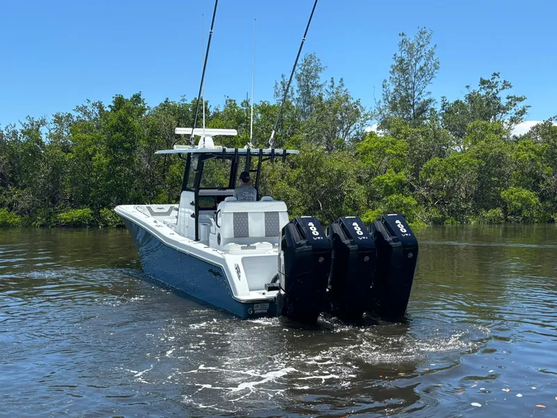 Slide: The Image of 2026 Invincible 36 Open Fisherman boat with triple engines on a calm waterway. - 3