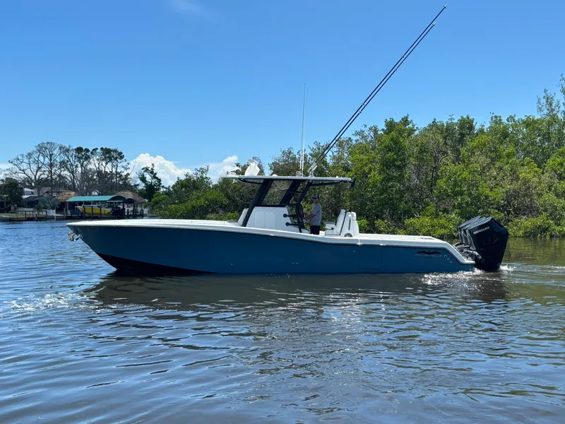 Slide: The Image of 2026 Invincible 36 Open Fisherman boat on calm water, surrounded by greenery. - 4