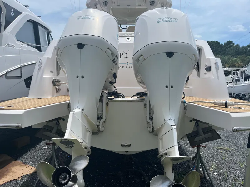 Slide: The Image of 2019 Regal 33 SAV boat with dual outboard engines, docked on a sunny day. - 11