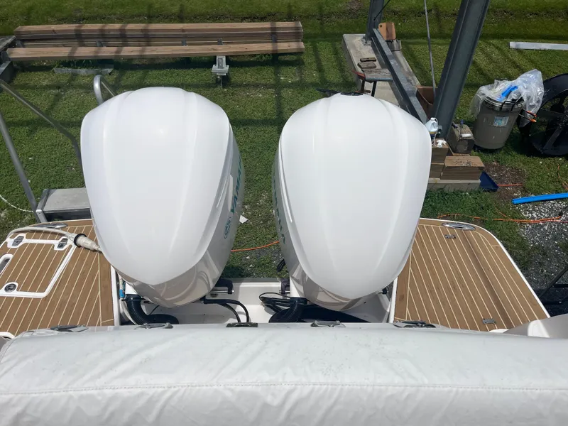 Slide: The Image of 2019 Regal 33 SAV boat with dual outboard engines on a wooden deck. - 13