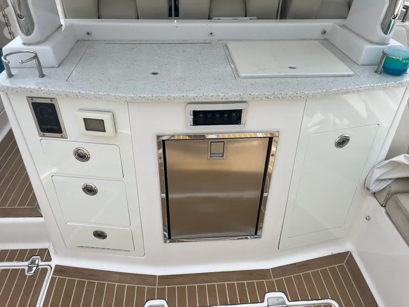 Slide: The Image of 2019 Regal 33 SAV boat kitchenette with sink, storage, and stainless steel fridge. - 21