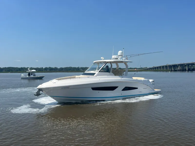 Slide: The Image of 2019 Regal 33 SAV boat cruising on a calm river near a bridge. - 3