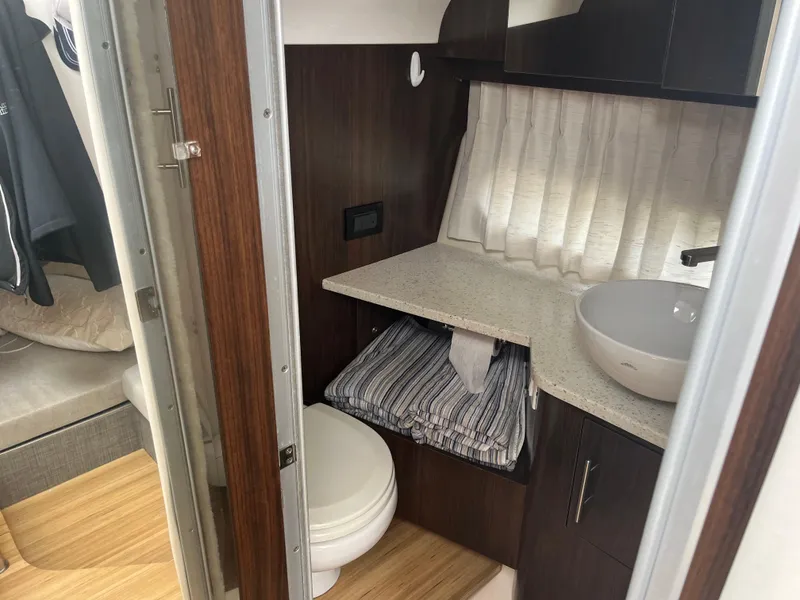 Slide: The Image of 2019 Regal 33 SAV boat interior bathroom with modern sink and wooden cabinetry. - 30