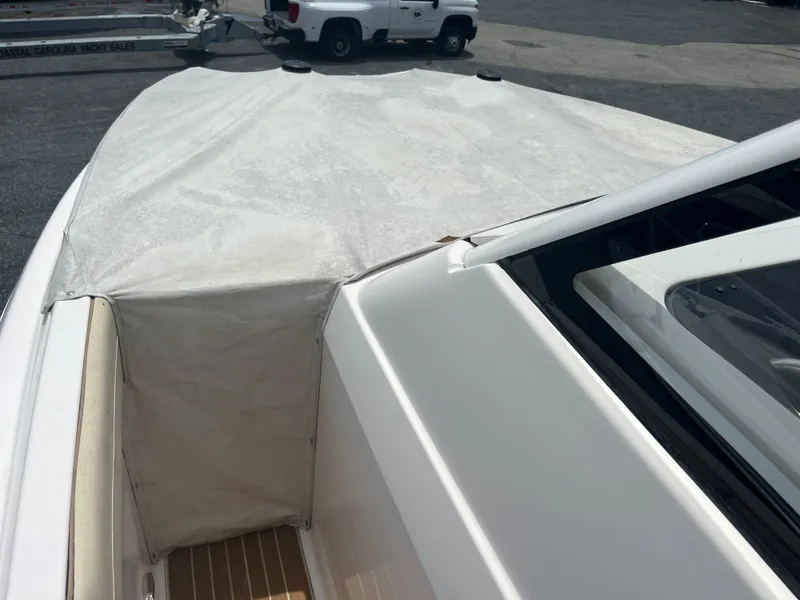 Slide: The Image of 2019 Regal 33 SAV boat with covered bow, parked near a trailer and vehicle. - 32
