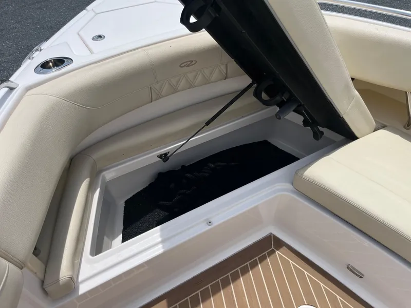 Slide: The Image of 2019 Regal 33 SAV boat with open storage compartment and beige seating. - 35