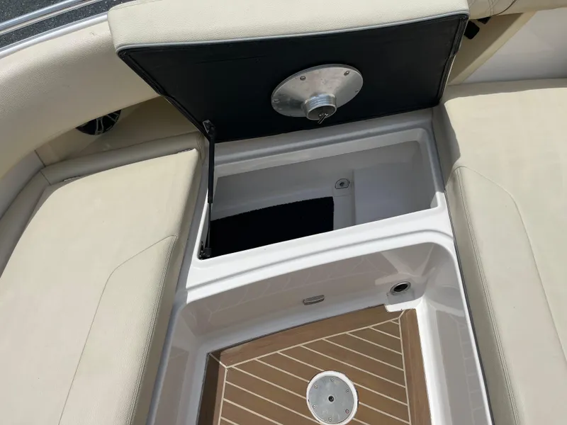 Slide: The Image of Open storage compartment on a 2019 Regal 33 SAV boat with cushioned seating. - 37