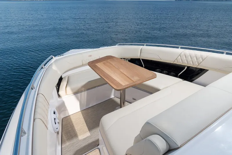 Slide: The Image of Manufacturer Provided Image: 2019 Regal 33 SAV boat with luxurious seating and wooden table on calm water. - 38