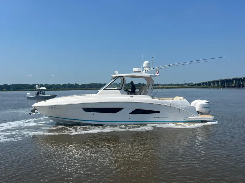 Slide: The Image of 2019 Regal 33 SAV boat cruising on a calm river near a bridge. - 4