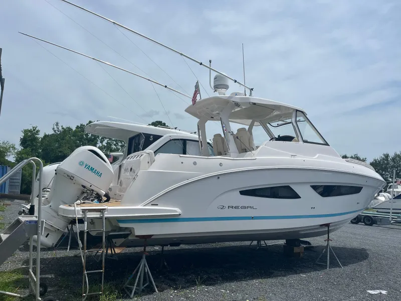 Slide: The Image of 2019 Regal 33 SAV boat with Yamaha engines on a trailer, parked outdoors. - 8
