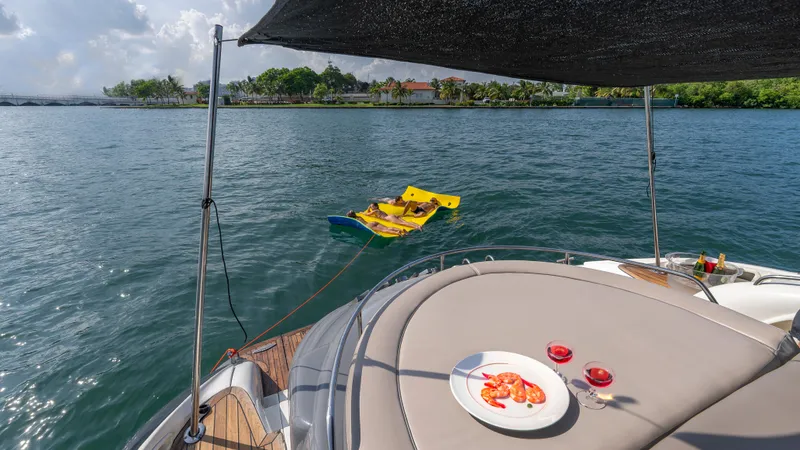 Slide: The Image of Sunseeker Predator 58 yacht with food and drinks on deck, floating in serene waters. - 16