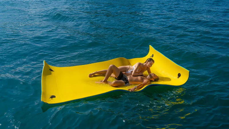 Slide: The Image of Couple relaxing on a yellow floating mat in the ocean. - 39
