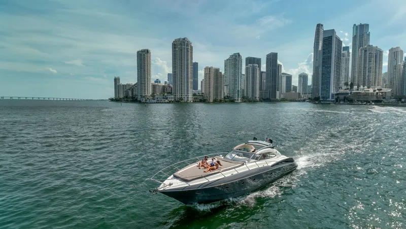 Slide: The Image of Sunseeker Predator 58 yacht cruising near city skyline, 1999 model. - 4