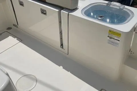 Slide: The Image of 2023 Cobia 237CC boat interior with storage compartments and a livewell. - 10