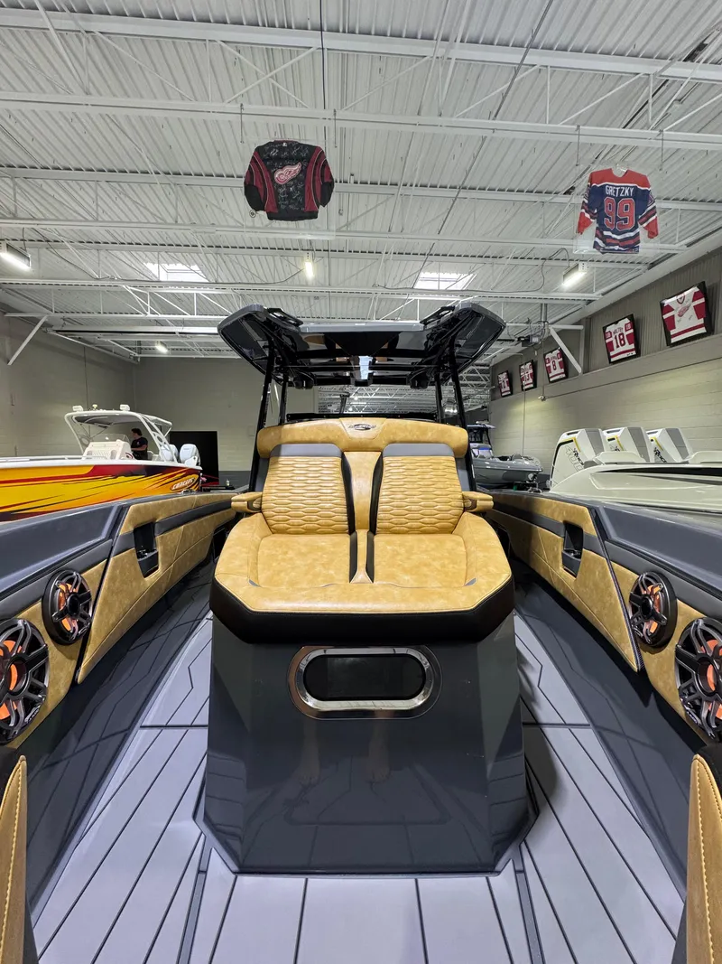 Slide: The Image of 2025 Sunsation 32 CCX boat interior with tan seating and modern design in showroom. - 14