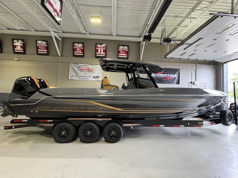 Slide: The Image of 2025 Sunsation 32 CCX boat in showroom, sleek design, triple-axle trailer. - 7