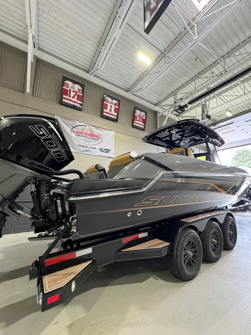 Slide: The Image of 2025 Sunsation 32 CCX boat on trailer in showroom, featuring sleek design and powerful engine. - 9