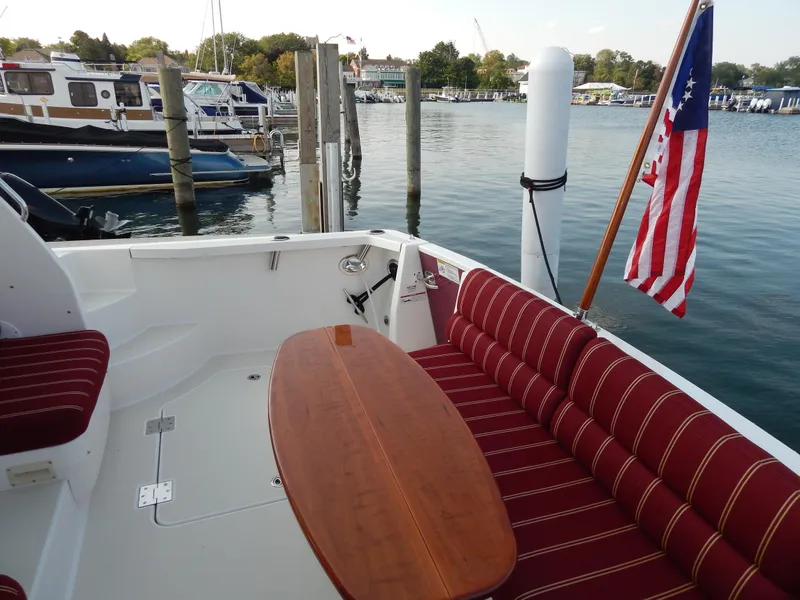 Slide: The Image of 2010 Sabre 40 Sedan yacht with striped seating and American flag at marina. - 10