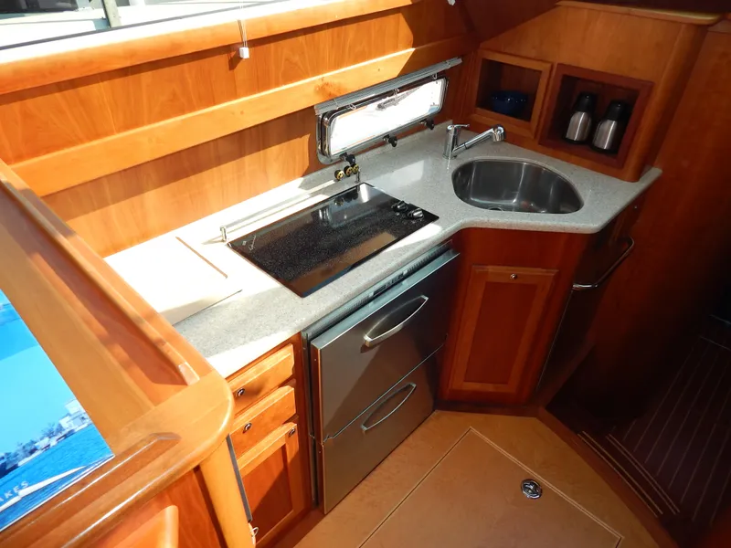 Slide: The Image of Luxurious 2010 Sabre 40 Sedan yacht kitchen with modern appliances and wooden cabinetry. - 18