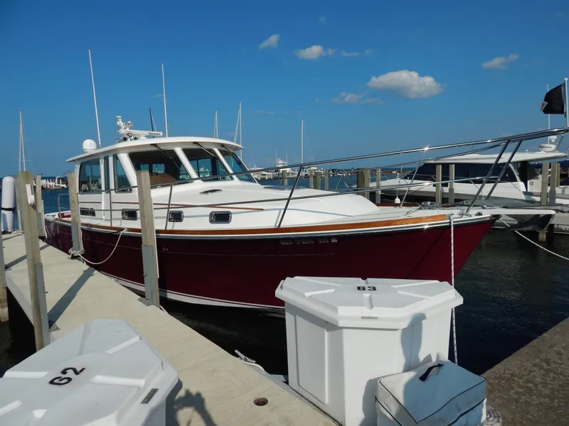 Slide: The Image of 2010 Sabre 40 Sedan docked at marina under clear blue sky. - 2