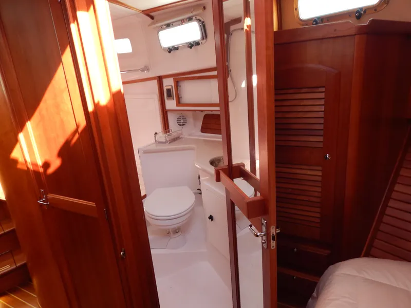 Slide: The Image of 2010 Sabre 40 Sedan yacht bathroom with wooden cabinetry and white fixtures. - 23