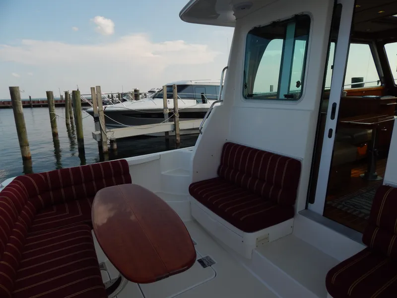 Slide: The Image of 2010 Sabre 40 Sedan yacht interior with striped seating and wooden table at marina. - 30