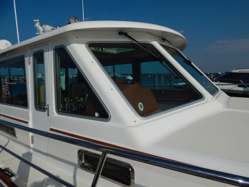 Slide: The Image of 2010 Sabre 40 Sedan yacht with sleek design and large windows at a marina. - 4