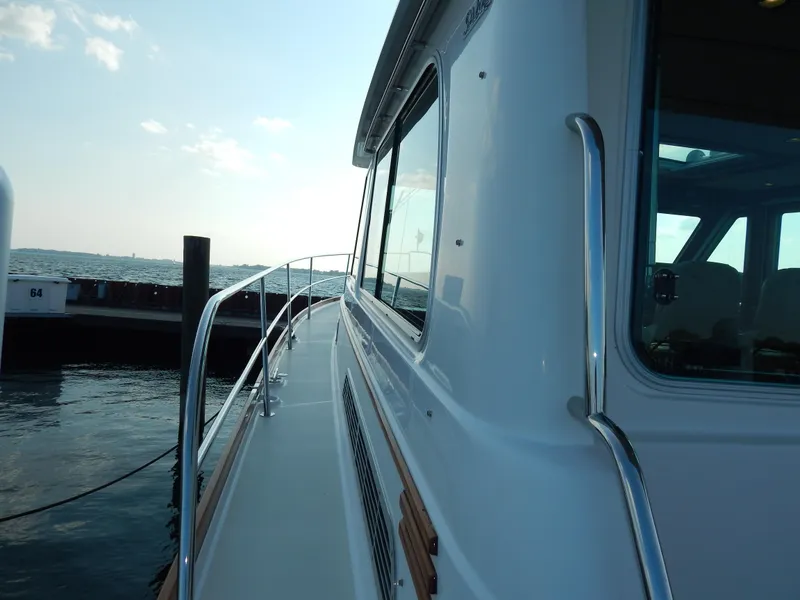 Slide: The Image of 2010 Sabre 40 Sedan yacht docked at marina, side view with railing and windows. - 41