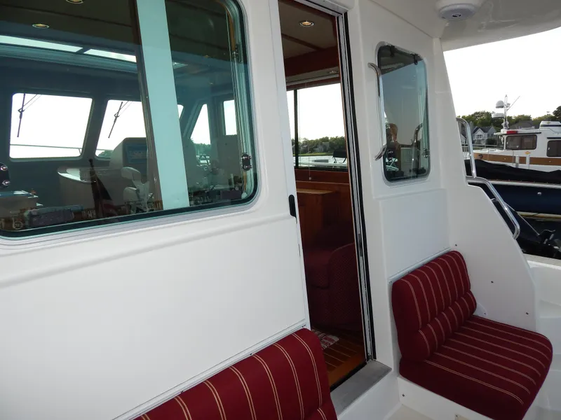 Slide: The Image of 2010 Sabre 40 Sedan yacht interior with red-striped seating and large windows. - 42