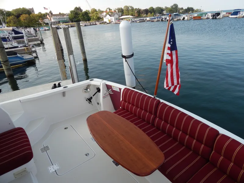 Slide: The Image of 2010 Sabre 40 Sedan yacht with red seating and American flag at marina. - 43